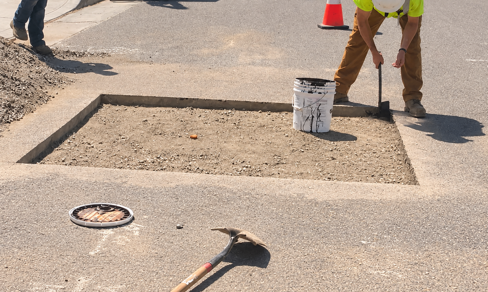 Woolworth crew member digging a utility trench in the street